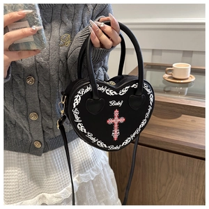 Gothic heart-shaped bag with white flame print and metal cross detail held by model