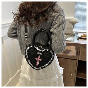 Black heart-shaped punk crossbody bag with cross and Baby print on a model