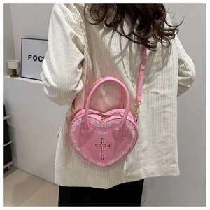 Pink heart-shaped Y2K crossbody bag with cross flame print and Baby lettering detail