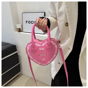 Detailed shot of pink heart-shaped bag with cross motif and Baby lettering decoration