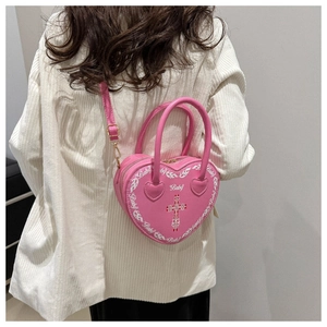 Detail der rosa herzförmigen Punk-Tasche mit weißem Kreuz und Baby-Schriftzug auf PU-Leder