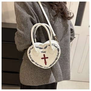 White heart-shaped punk bag with cross print shown from a stylish side view angle