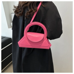 Detail of bright pink geometric crossbody bag featuring a unique circular handle design