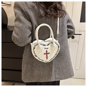 Detailed view of a white heart-shaped punk bag with gothic cross and Baby flame print