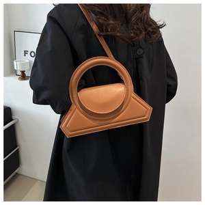 Detail van camelbruine geometrische handtas met rond handvat en stijlvolle klep