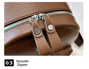 Detail view of smooth dual metal zippers on brown lychee texture leather backpack