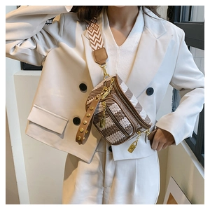 Detail of crossbody chest bag with wide geometric strap and golden zipper accents