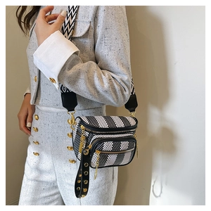 Detail of crossbody bag with black white stripes and stylish wide geometric strap