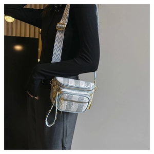 Detailed view of blue checkered crossbody bag with multiple zippers and wide strap