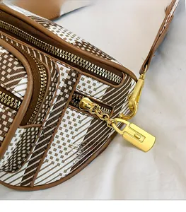 Detail of smooth gold zipper and geometric pattern on retro crossbody shoulder bag