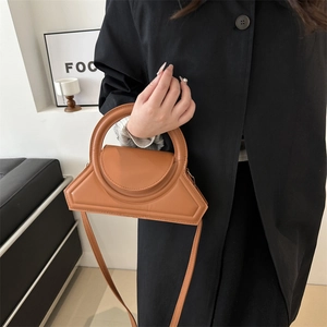 Brown geometric trapezoid handbag with large round handle and adjustable shoulder strap