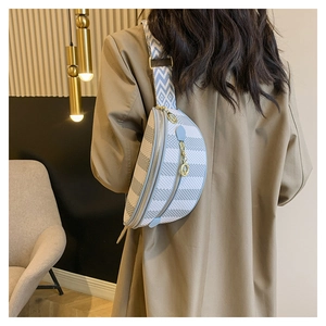 Detail of light blue geometric checkered waist bag with stylish wide woven strap and gold chain