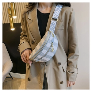 Close-up of a plaid crescent chest bag featuring a geometric woven strap and gold hardware