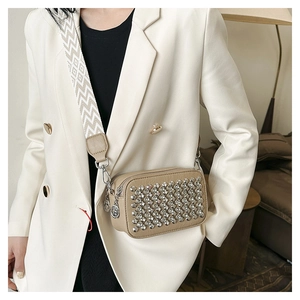 Detailed view of rhinestone crossbody bag featuring geometric patterned wide strap