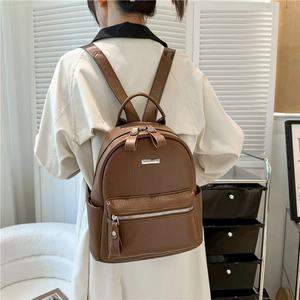Brown soft leather backpack for women shown on model in a minimalist modern interior