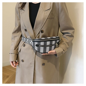 Detail of checkered fanny pack with adjustable woven strap and silver metal zipper