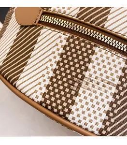 Close-up of geometric brown and white checkered fabric with premium metal zipper detail