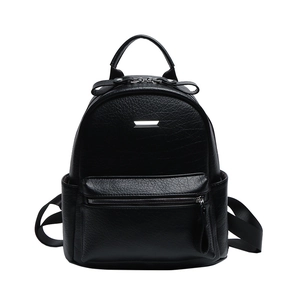 Close-up of litchi grain PU leather texture and silver metal buckle on black backpack