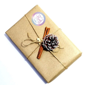 Rainbow laser Thank You stickers on kraft gift box with pinecone and cinnamon decor