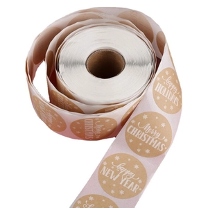 Kraft paper rolls of festive Happy New Year and Merry Christmas round holiday stickers