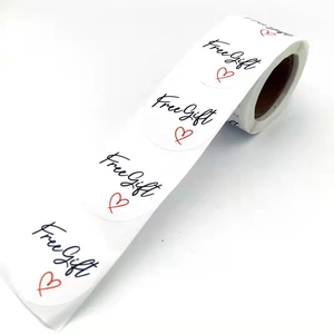 Roll of white Free Gift stickers with black script and red heart for gift labels