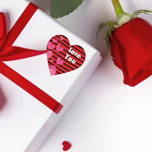 Valentine's Day heart sticker with Love You text on a striped gift box with a red rose