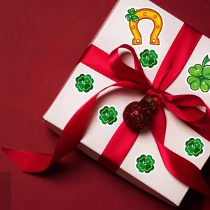 St. Patrick's Day shamrock and horseshoe stickers on a gift box with a red ribbon