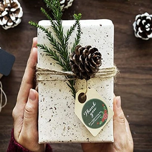 Brown kraft paper gift box with pine cone, twine, and Thank You sticker label