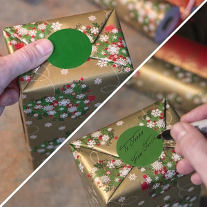 Close-up of green round adhesive label on gift box with handwritten names for Christmas