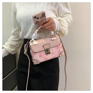 Detailed view of pink floral embroidery bag with metal buckle and silk scarf handle decor