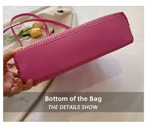 Detailed bottom view of rose pink woven handbag with smooth leather base and fine stitching
