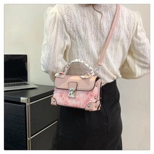 Detail of pink embroidered box bag with silk scarf handle and metal latch clasp