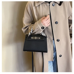 Detail der schwarzen Kelly-Tasche aus Leder mit bedrucktem Seidentuch und Silberverschluss