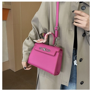 Detailansicht der rosafarbenen Kelly-Tasche mit Seidenschal-Griff und Silberverschluss