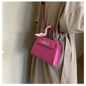 Detail der rosaroten Tasche aus Litschileder mit Seidentuch am Griff und Metallverschluss