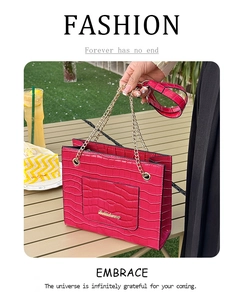 Détail du sac fourre-tout rose vif effet crocodile avec chaîne dorée et logo en métal