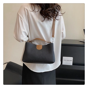 Detailansicht der PU-Handtasche mit Krokodilmuster und braunen Trägern am Modell