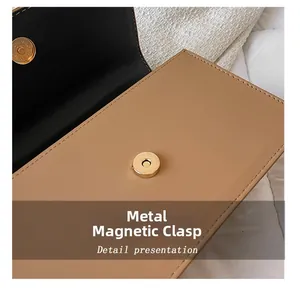 Gros plan sur le fermoir magnétique doré et les coutures du sac marron en cuir