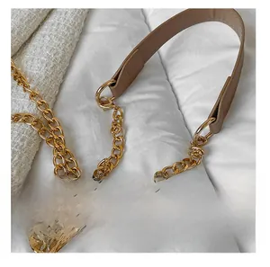 Détail de la bandoulière en chaîne dorée avec coussin d'épaule en cuir marron clair