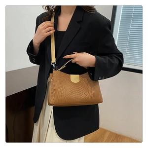 Close-up of brown snake embossed tote bag showing textured faux leather and retro handle