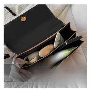 Vue intérieure du sac enveloppe à motif pierre contenant téléphone et cosmétiques