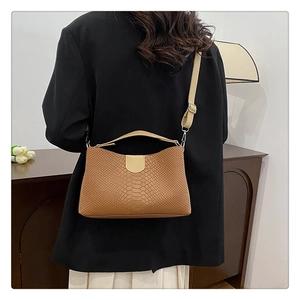 Detailed view of crocodile pattern PU leather shoulder bag on model for elegant daily use