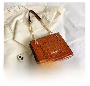 Détail du sac cabas marron à motif croco avec bandoulière chaîne dorée et logo