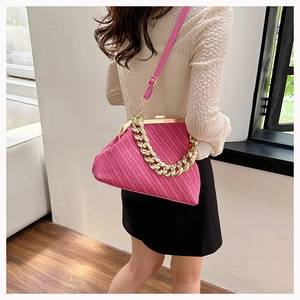 Detail of fuchsia shell bag with woven texture, chunky gold chain and leather strap