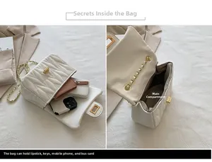 Detail view of white quilted crossbody bag interior with gold turn-lock and chain strap
