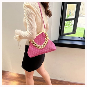 Detailed view of rose pink woven shell bag with gold chunky chain and clasp closure