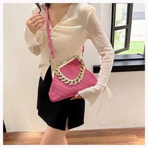 Detail of rose red woven shell bag with gold metal frame and thick chain handle
