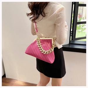 Close-up of rose red shell bag featuring V-shaped knit texture and gold chain handle