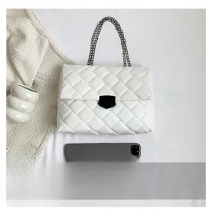 Weiße Stepptasche mit Kette neben Tablet zeigt die großzügige Kapazität und Größe