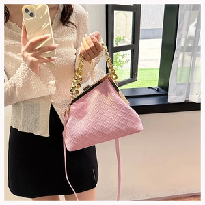 Detailed view of pink shell bag with textured stripe fabric and gold clasp closure